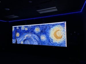 View from the back right corner of the room. On screen: Van Gogh's Starry Night