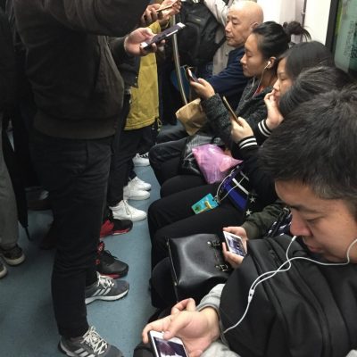 crowded Beijing Subway riders using cell phones
