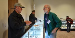 Odyssey Conference attendees talking over artifacts display