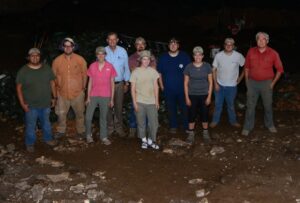 group of male and female students standing in riverbed at night