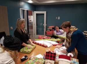From L to R: Madison Bourgeois (Student Worker), Margaret Lomas Carpenter (Master’s Program Manager), Rochelle Read (Academic Advisor II) and Paula Verdegaal (Academic Advisor II) wrap presents for Mosaic.