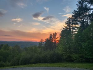 Sun setting behind forested hills in Vermont