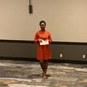 Ivylove Cudjoe displaying The Pansy E. Jacobs Jackson National Students Research Competition award.