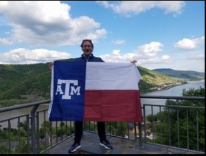 Professor David Brenner is waving the Aggie-Texas flag at Stahleck Castle in the village of Bacharach, overlooking the Rhine river.