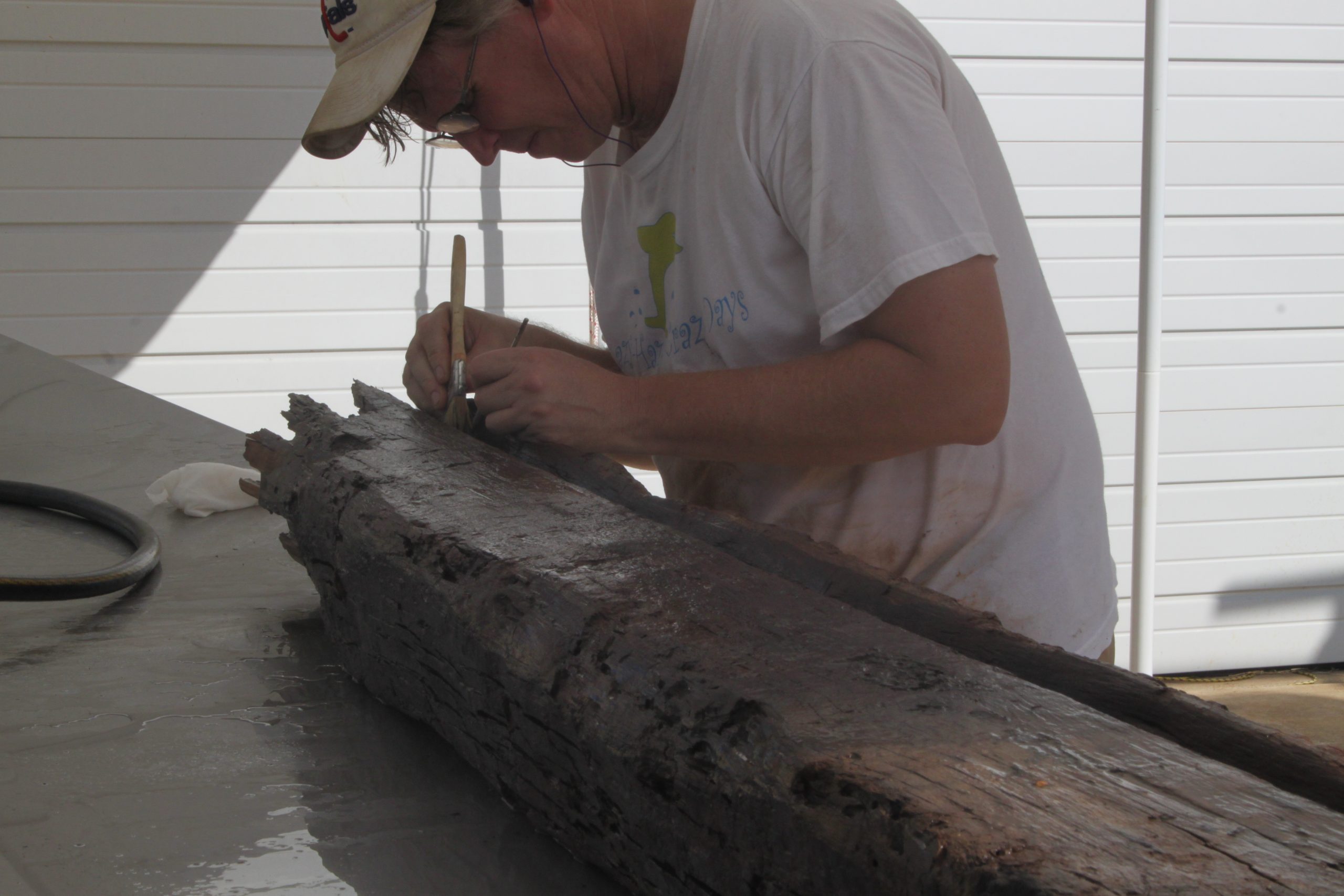 man inspecting the timbers carfully with large tweezers