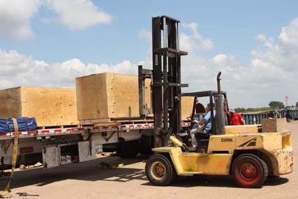 forklift unloading creates from flatbed truck