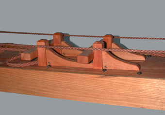 The riding bitts for securing the cables while the ship is at anchor. The bitts comprise the vertical pins, standards (robust knees) and the crosspiece.