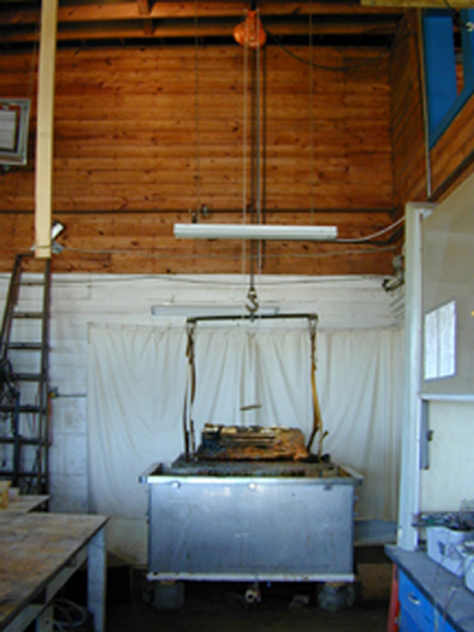 Stainless steel vat with the crate on the grate, and the chain hoist above