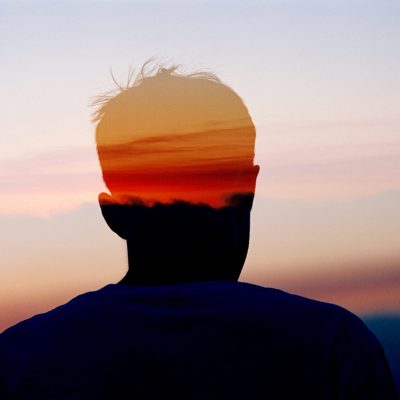 Thoughtful person on sunset background