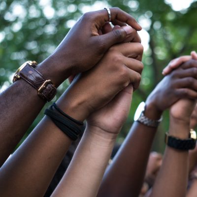 hands of different skin colors holding each others hands