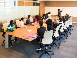 Group at conference table watching speaker
