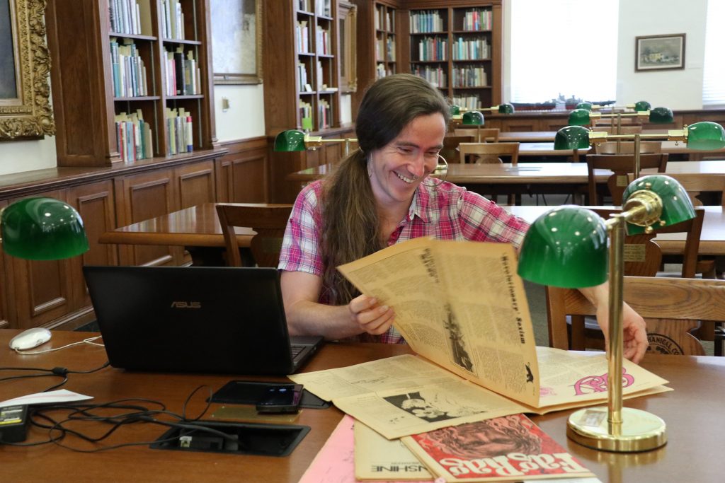 Nikita Shepard perusing periodicals in the Don Kelly Research Collection of Gay Literature and Culture