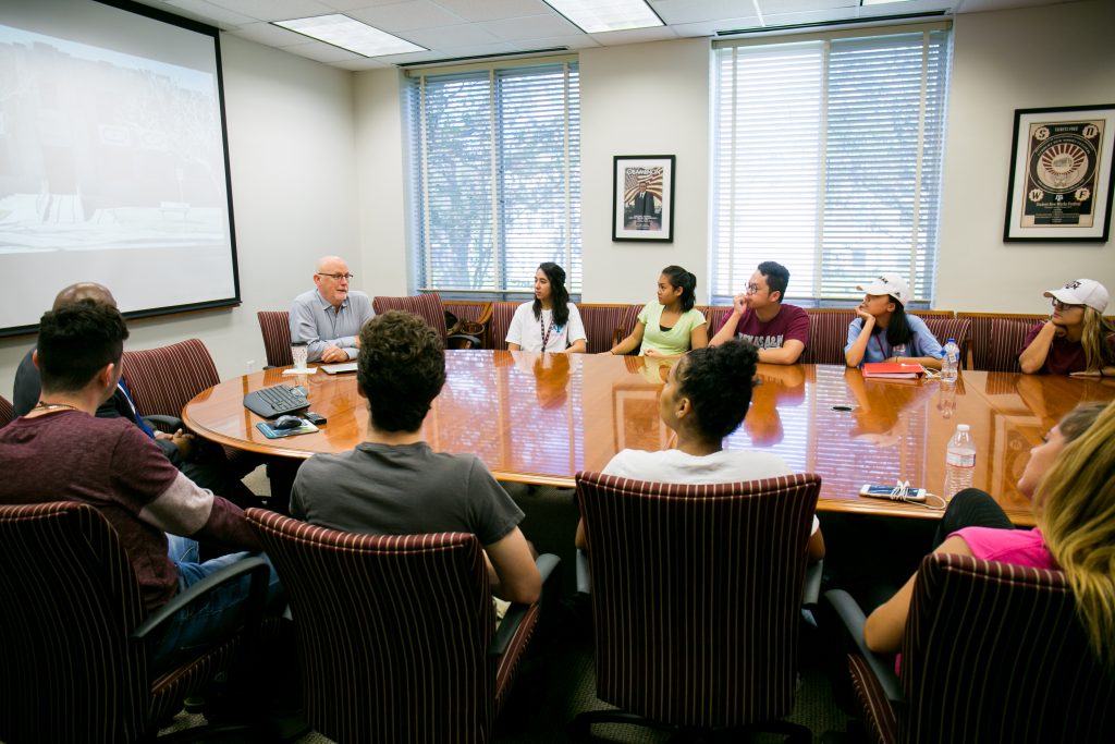 Photo of Dennis Segers at a conference table with students