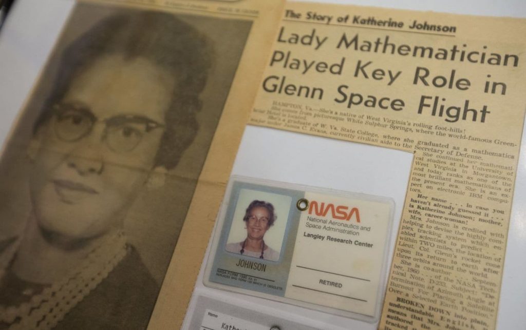 Photo of newspaper with headline says "Lady Mathematician Played Key Role in Glenn Space Flight," along with NASA badge of Katherine Johnson.