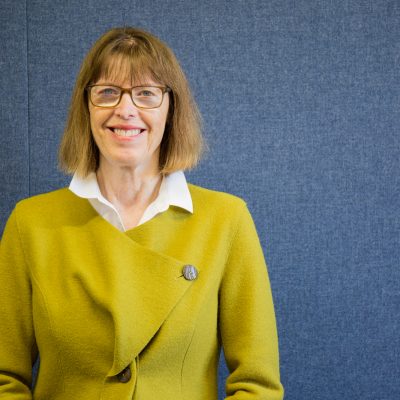 Dr. Patricia Thornton poses in front of a blue background.