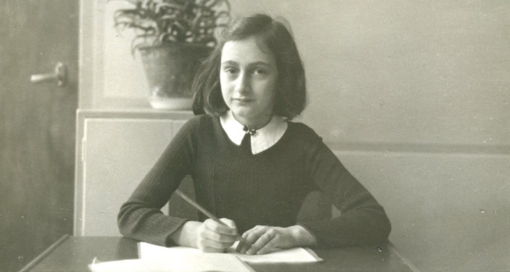Anne Frank sitting at desk