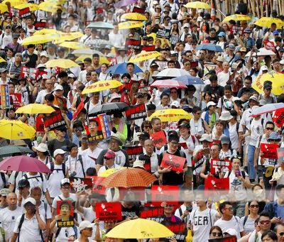 In Asia, umbrellas are commonly used as a form of sun protection. AP Photo/Kin Cheung