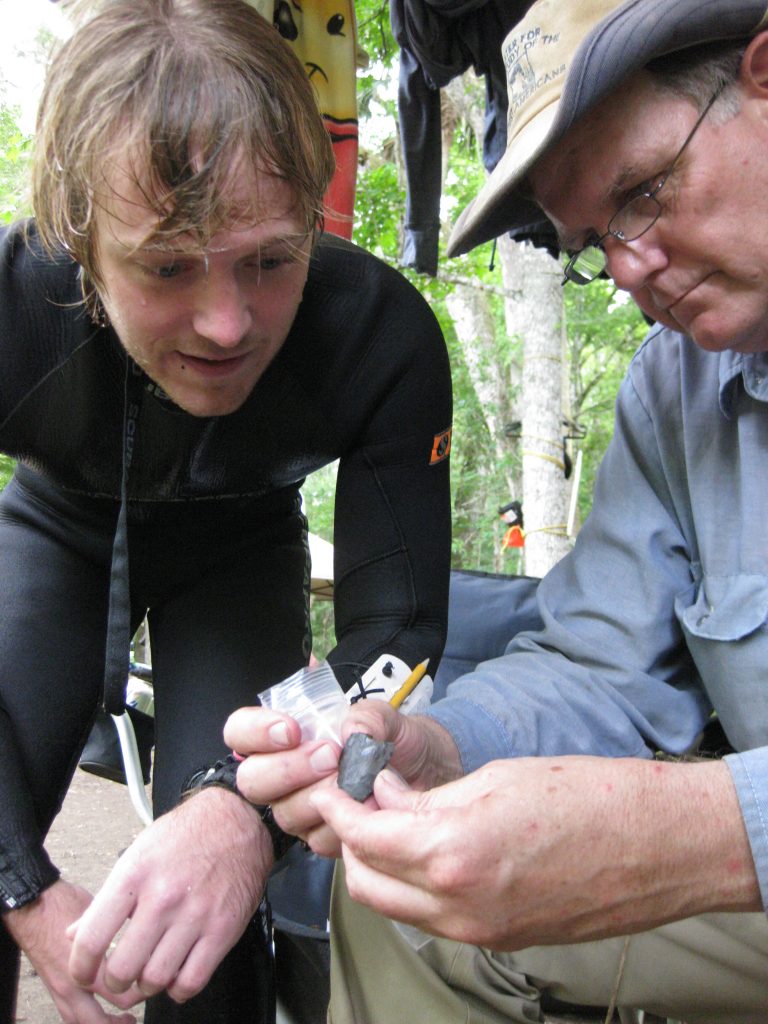 Michael Waters (right) and graduate student Morgan Smith examine 14,600 year old knife at Page-Ladson on the day of its discovery. Photo: provided.