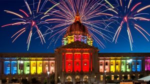 Building with rainbow lighting and fireworks during virtual Pride Month celebration.