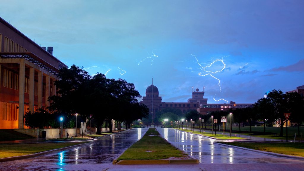 Texas A&M University on a rainy day with lightning dancing across the sky.