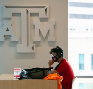 Student wearing a mask as they study on campus.