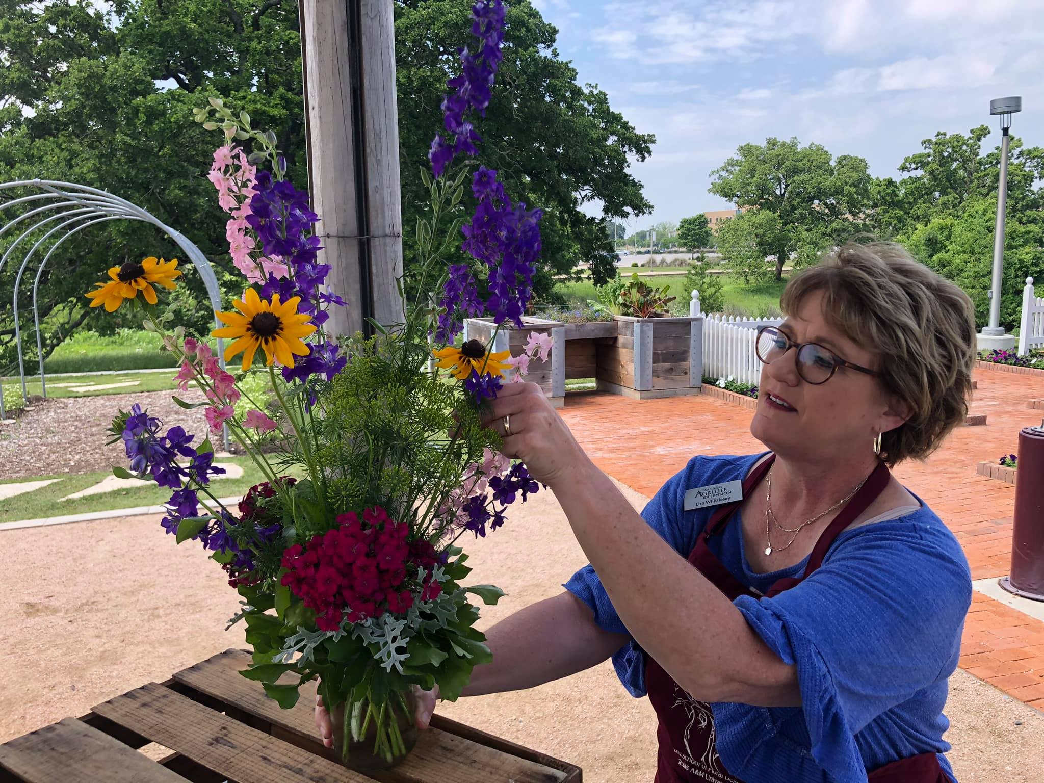Faculty member teaching a floral design class in The Gardens on campus.