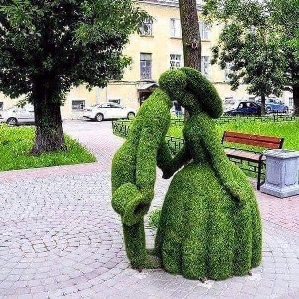 Topiary of a man and woman kissing.