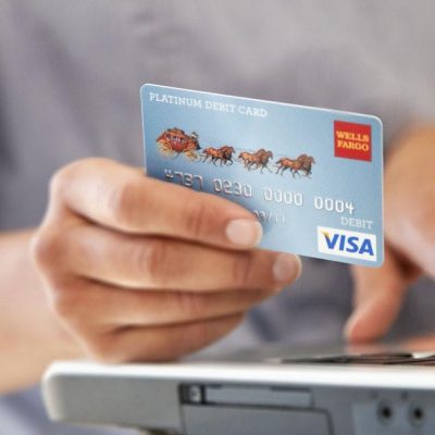 Photo of a hand holding a credit card as the person prepares to pay.