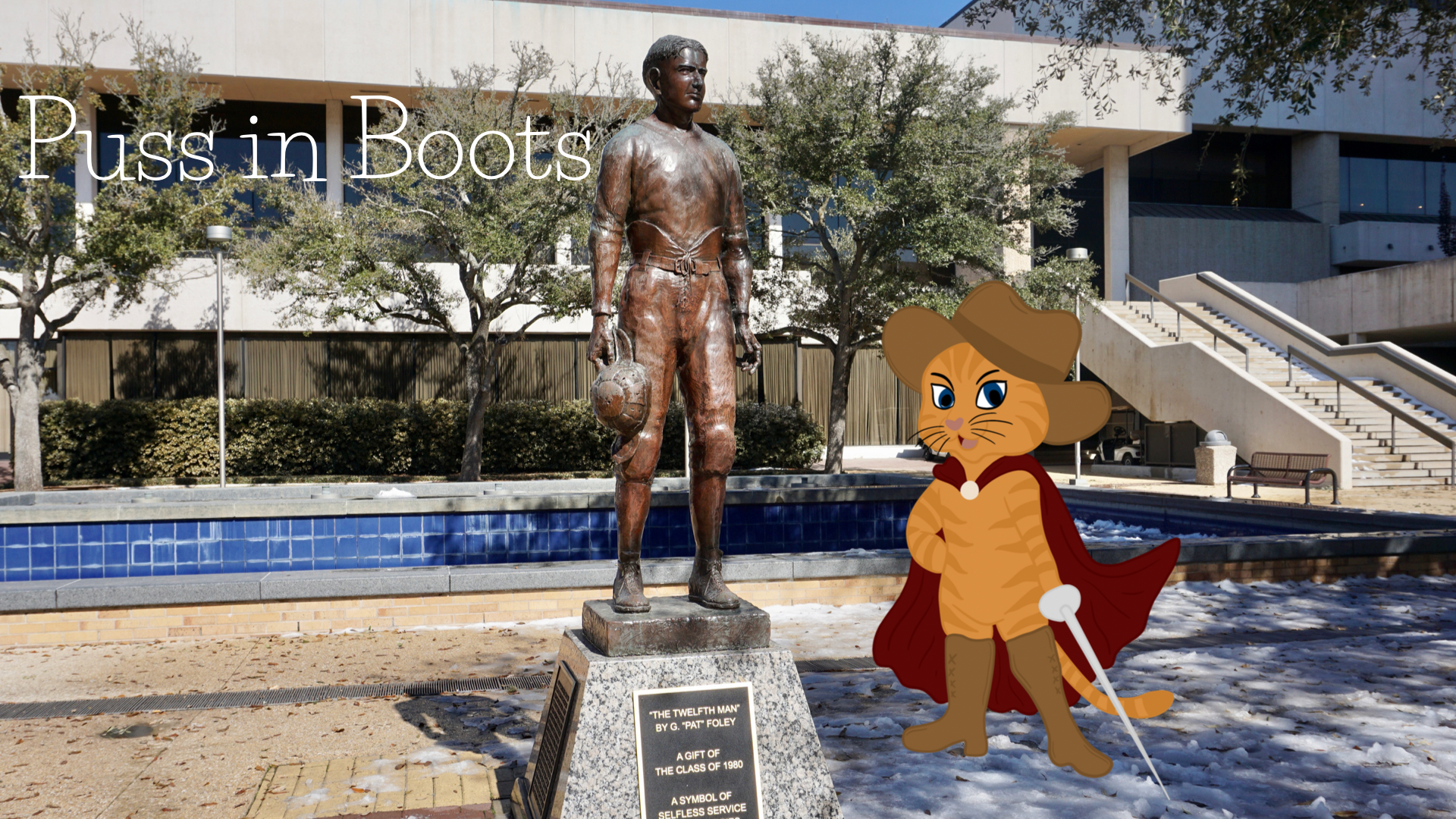 On a snowy day in Aggieland, puss poses for a photo with the statue of E. King Gil in Rudder Plaza.