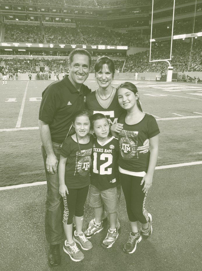 Green and white photo of the Hegar family at a Texas A&M football game.