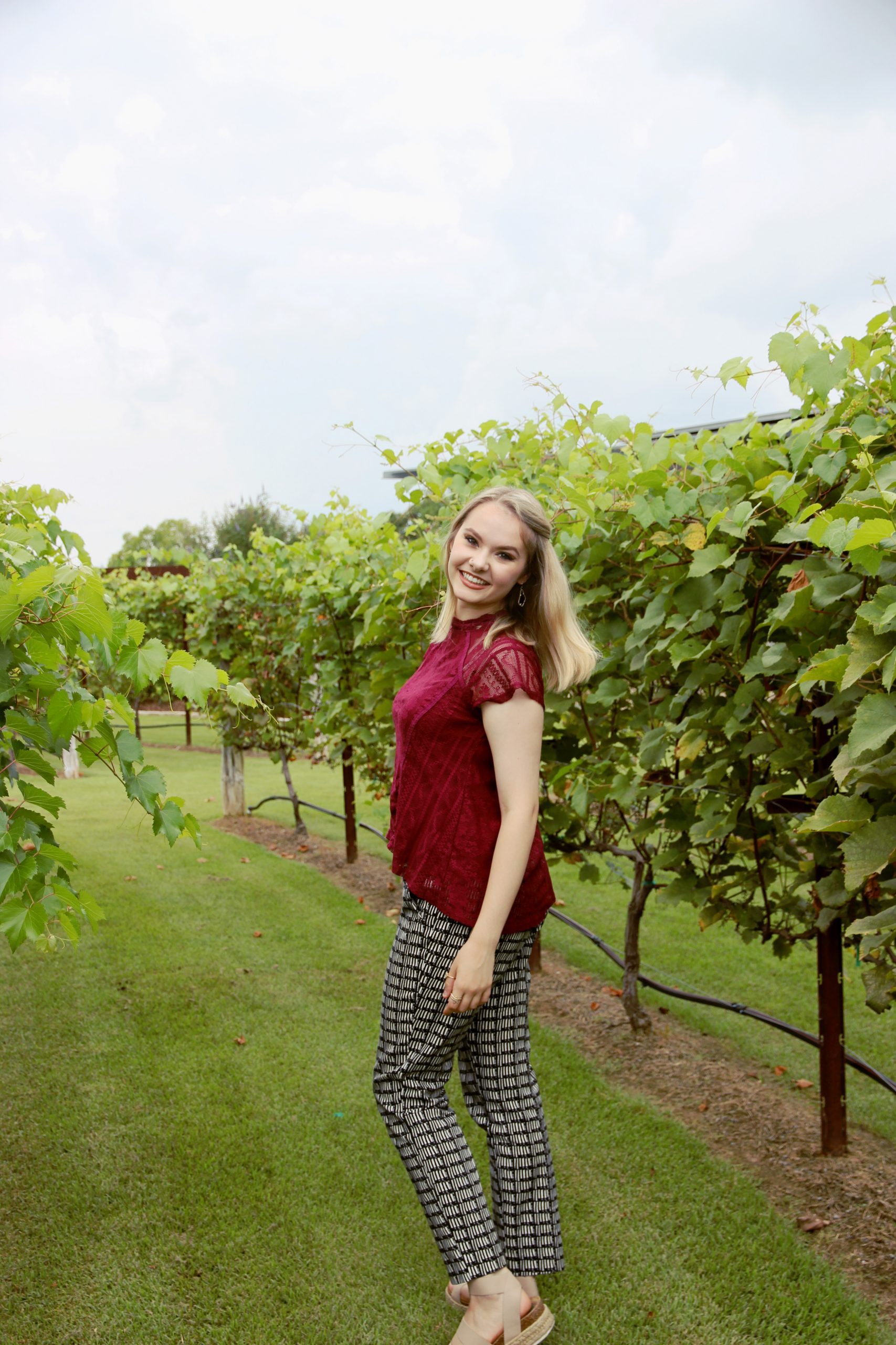 Natalie Parks takes a stroll through the grape vines in The Gardens on campus.