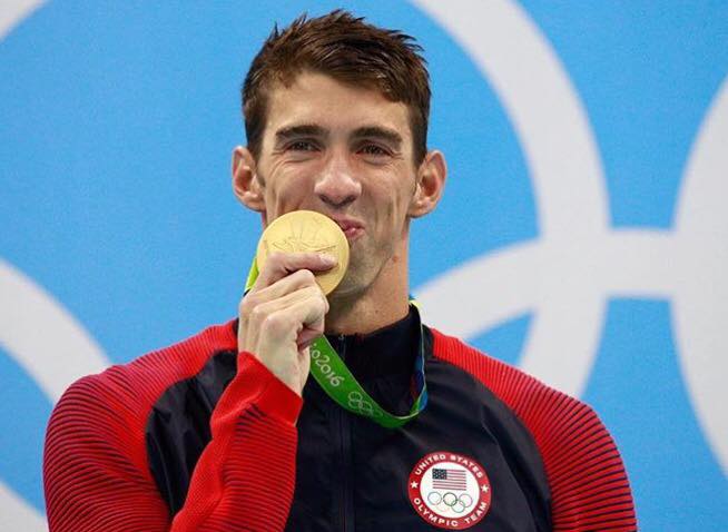 Michael Phelps kisses one of his gold medals. 