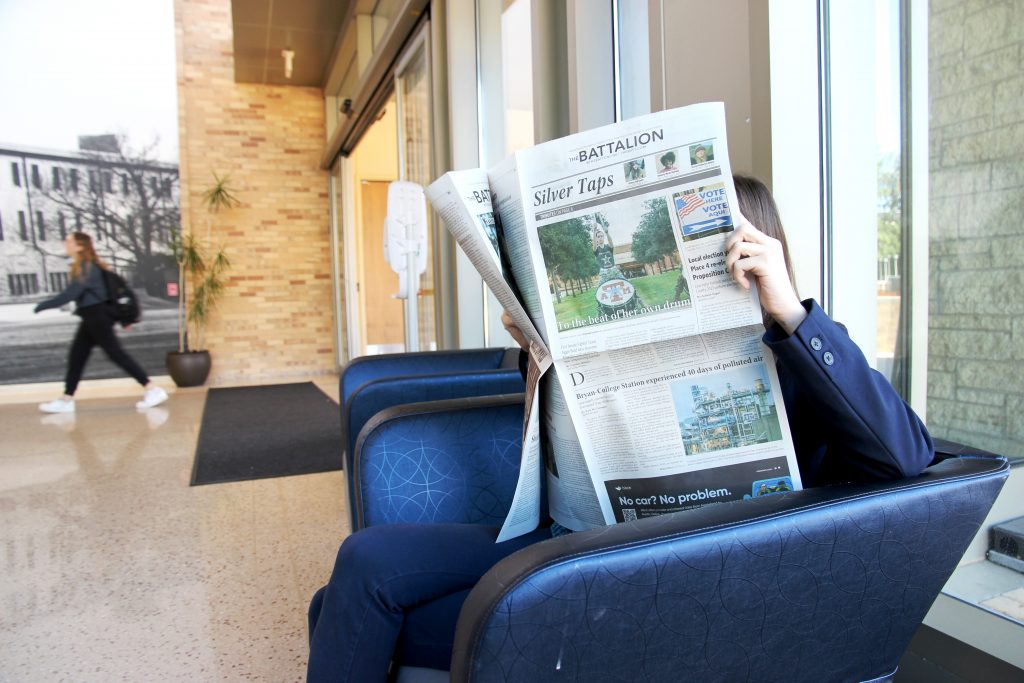 Photo of a girl reading The Battalion in the MSC.