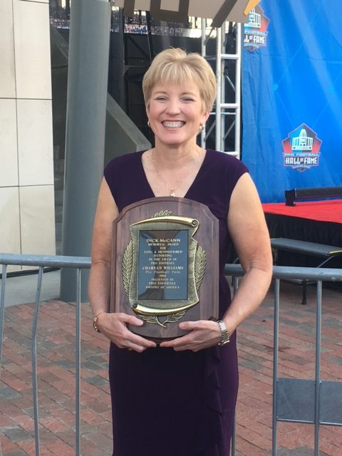 Photo of Charean Williams holding her Bill Nunn Award plaque outside the Pro Football Hall of Fame.