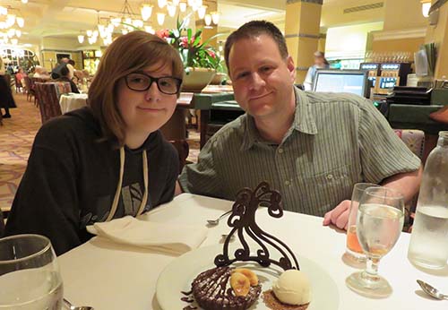 Raymond and his daughter enjoy a desert at a restaurant. 
