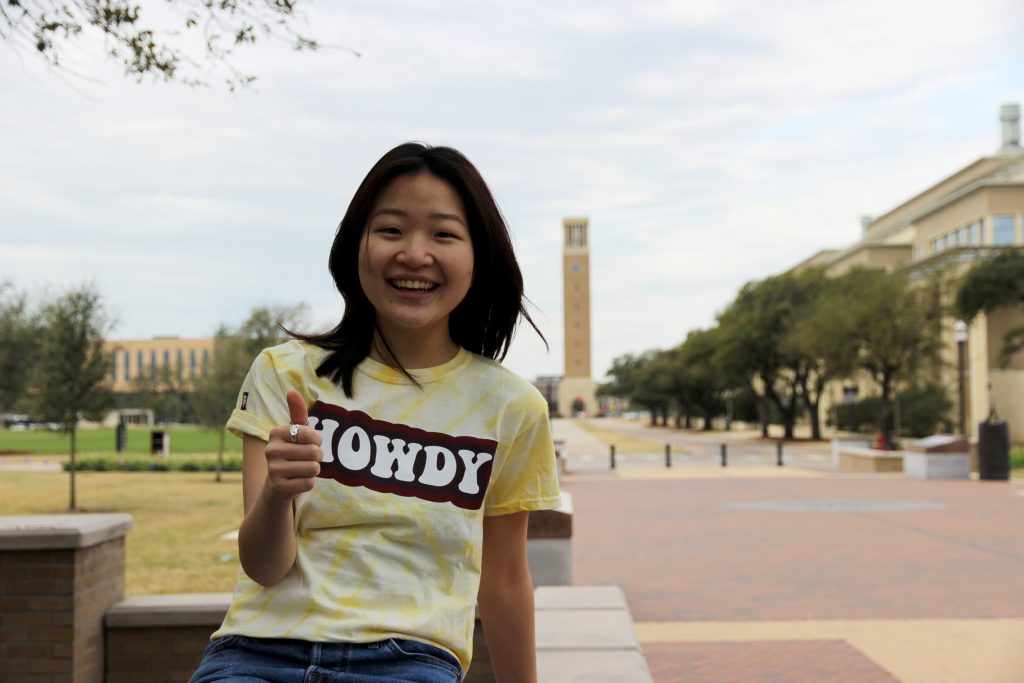 Stella Lee poses for a photo on Military Walk with a shirt that reads, "Howdy."