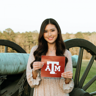 Madelaine Setiawan poses for a photo holding her acceptance letter from Texas A&M University.