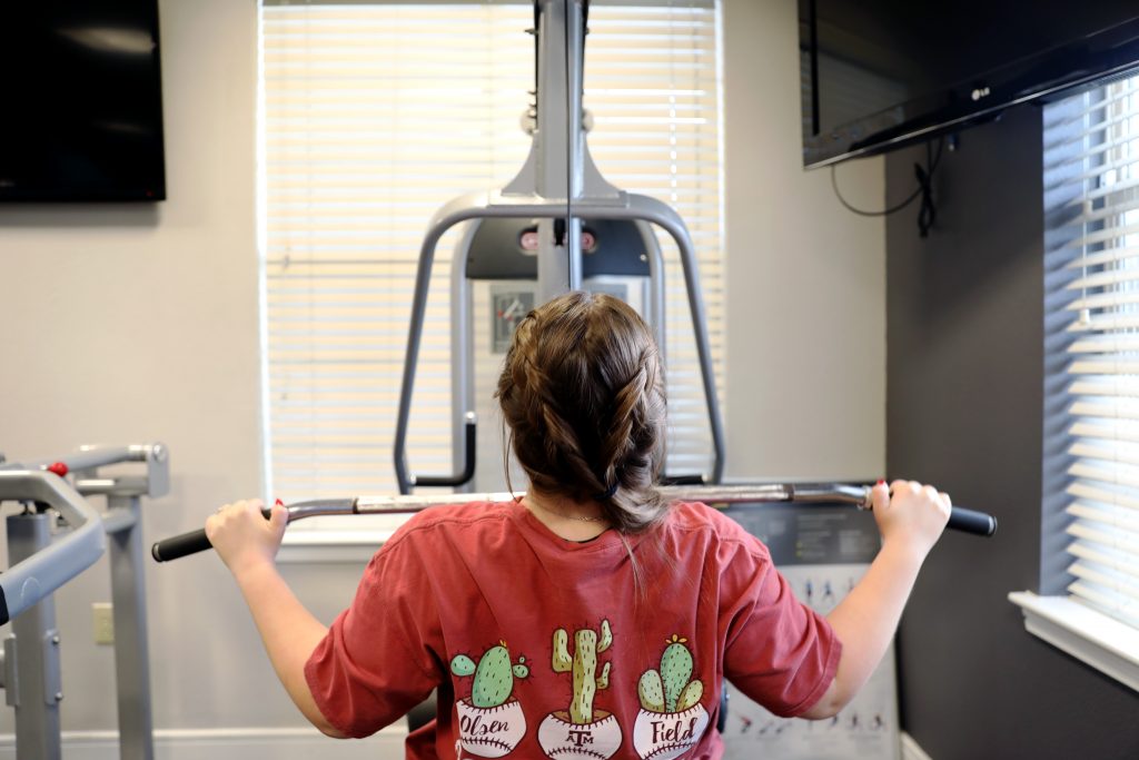 Photo of woman using rowing machine in a gym.