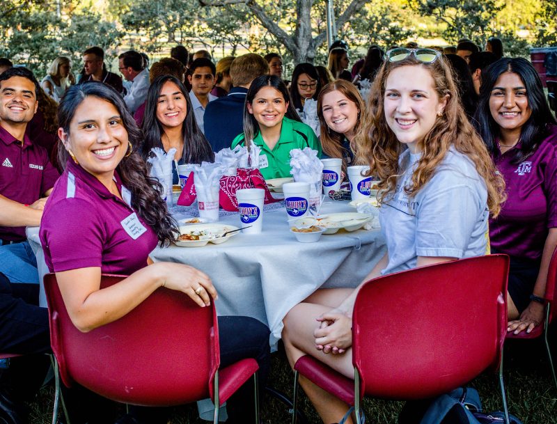 students at a meal table outdoors together